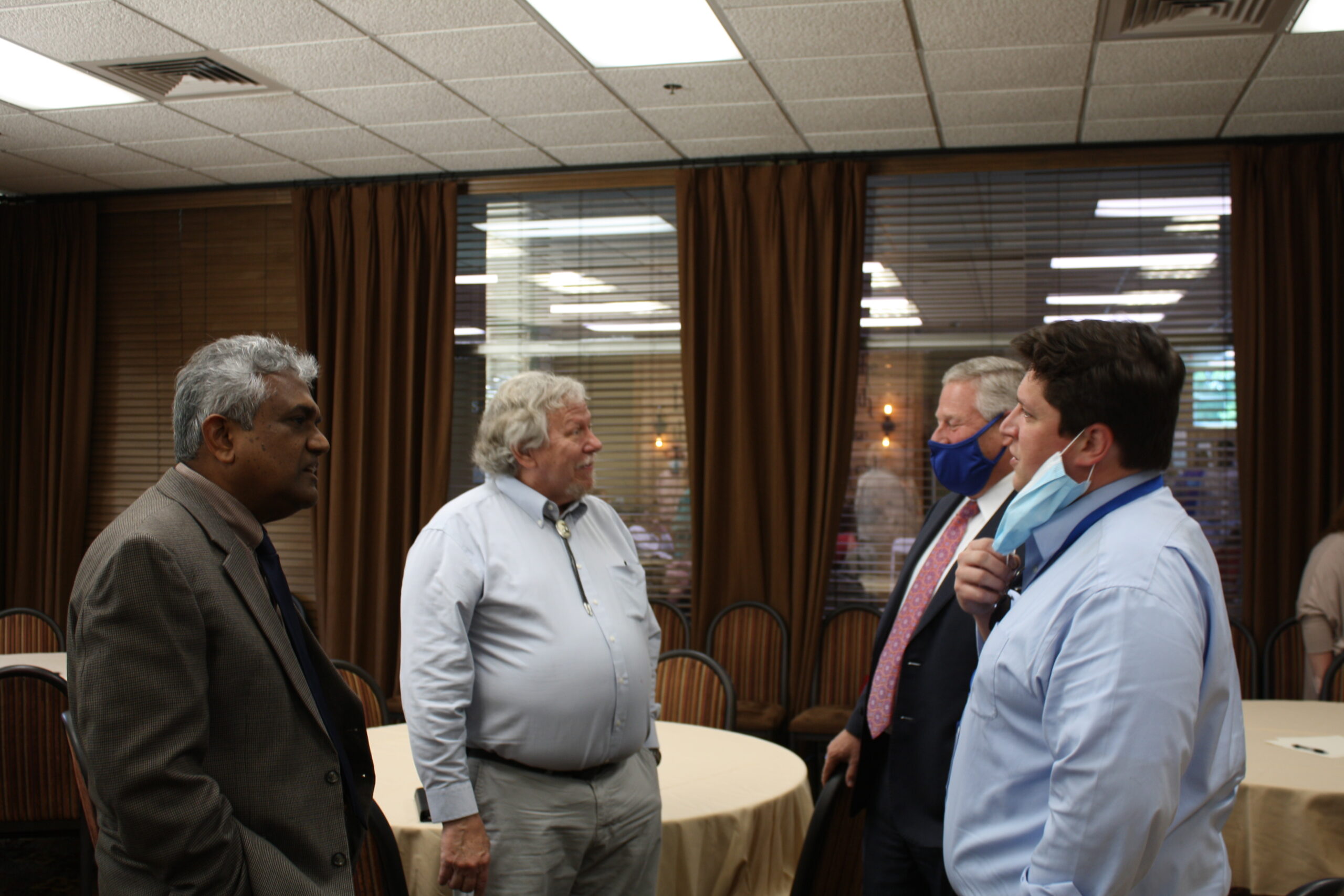 l-r Dr. Dave Rampersad, Dr. Al Schlundt, President Mike Williams and Wesley Schlundt chat during Al Schlundt's retirement ceremony. Schlundt served as a biologist and an educator.