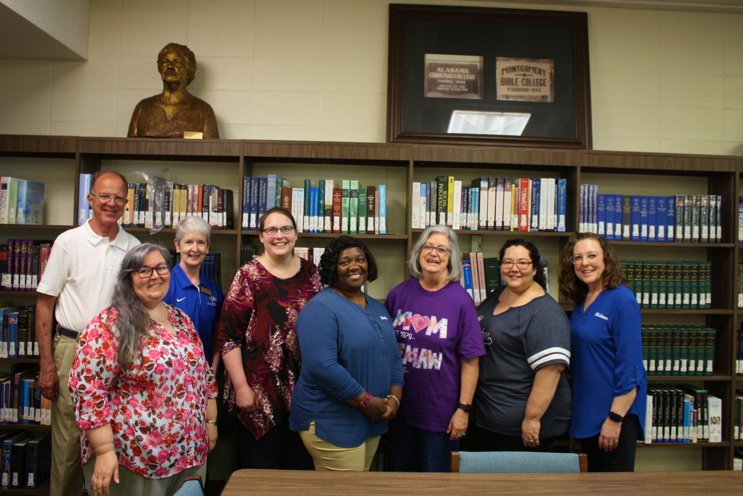 Barbara Kelly stands among her colleagues at the Gus Nichols Library.